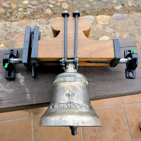 Campana montada en un yugo de madera con herrajes de hierro
